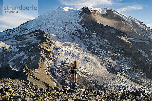Fitte Frau steht auf einer Klippe neben dem Mount Rainier