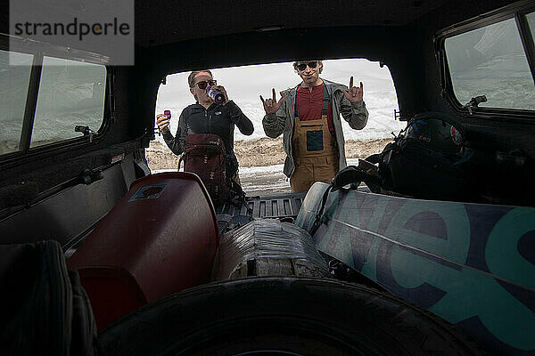 Zwei Backcountry-Snowboarder ziehen Ausrüstung von einem Lastwagen