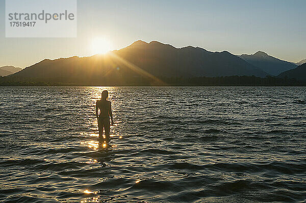 Frau schwimmt im Bikini bei Sonnenuntergang am Lake Wenatchee