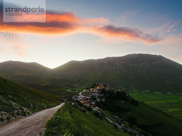 Blick auf das Dorf Castelluccio di Norcia mit Linsenfeldern und Bergen bei Sonnenaufgang  Perugia  Umbrien  Italien  Europa