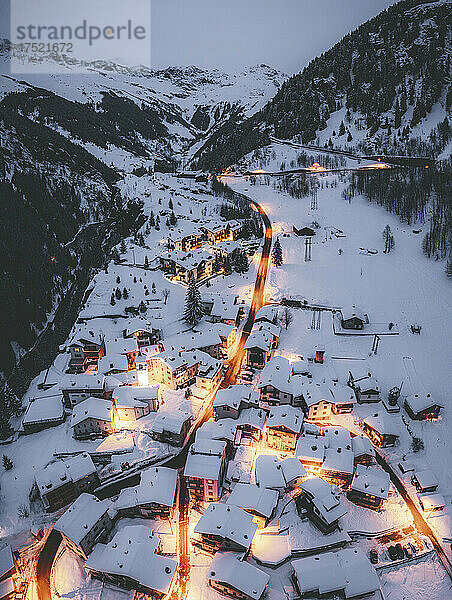 Luftaufnahme beleuchteter  schneebedeckter Berghütten  Pianazzo  Madesimo  Valle Spluga  Valtellina  Lombardei  Italien  Europa