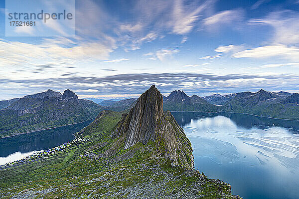 Wolken bei Sonnenuntergang über dem unberührten blauen Wasser der Fjorde und des Segla-Gebirges  Insel Senja  Kreis Troms  Norwegen  Skandinavien  Europa