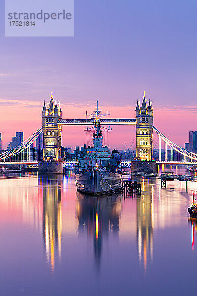 Sonnenaufgangsansicht der HMS Belfast und der Tower Bridge  die sich in der Themse spiegeln  mit Canary Wharf im Hintergrund  London  England  Vereinigtes Königreich  Europa