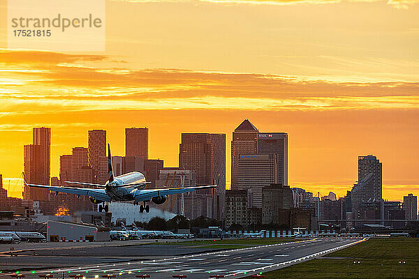 Flugzeuge landen am London City Airport bei Sonnenuntergang  mit Canary Wharf und der O2 Arena im Hintergrund  London  England  Vereinigtes Königreich  Europa