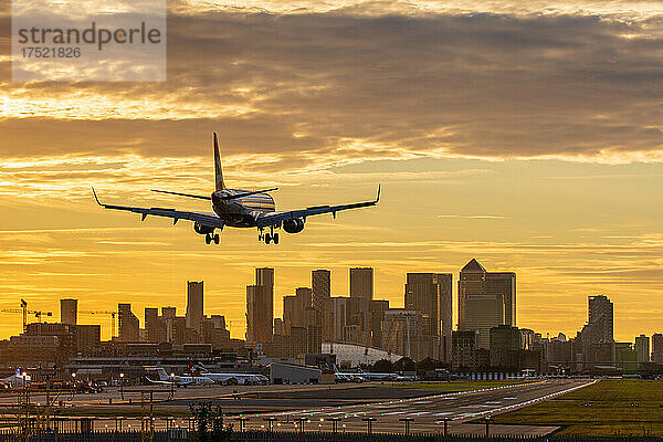Flugzeuge landen am London City Airport bei Sonnenuntergang  mit Canary Wharf und der O2 Arena im Hintergrund  London  England  Vereinigtes Königreich  Europa