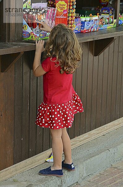 Mädchen im roten Kleid vor Kiosk mit Süßigkeiten  Villaricos  Andalusien  Spanien  Europa