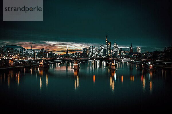 Blick auf Frankfurt und die beleuchtete Skyline von Frankfurt  Commerzbank  Hessische Landesbank  Deutsche Bank  Europäische Zentralbank  Skyper  Sparkasse  DZ Bank  Langzeitbelichtung  Sonnenuntergang  Nachtaufname im Petrol style  Frankfurt  Hessen  Deutschland  Europa