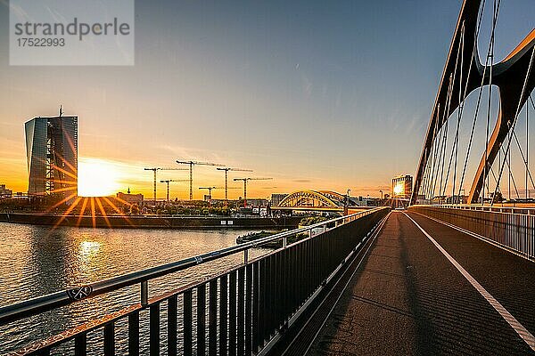 Blick über den Main  Sonnenuntergang hinter der EZB  Brücke und im Hintergrund Baukräne  Frankfurt am Main  Hessen  Deutschland  Europa