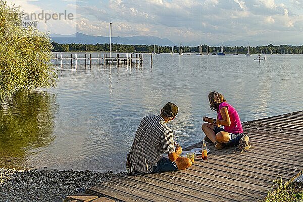 Mann und Frau sitzen abends am Steg  Kleines Seehaus  Pischetsried  St. Heinrich  Starnberger See  Oberbayern