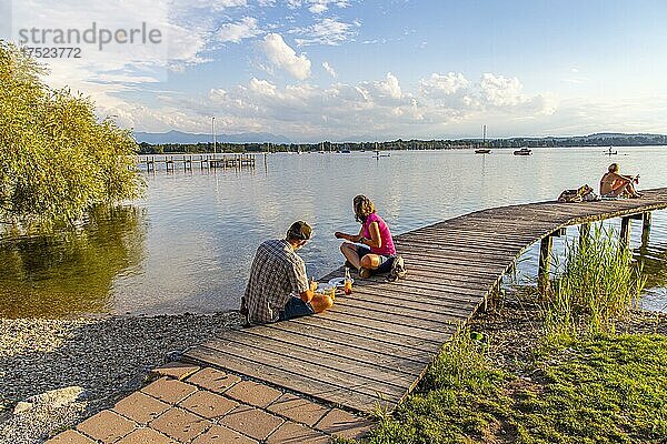 Mann und Frau sitzen am Steg  Kleines Seehaus  Pischetsried  St. Heinrich  Starnberger See  Oberbayern