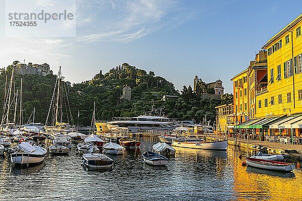 Boote ankern im Hafen von Portofino im Morgenlicht  dahinter das Castello Brown und die Kirche San Giorgio  Portofino  Ligurien  Italien  Europa