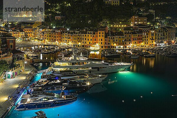 Luxus Yachten und Boote ankern im Hafen Portofino bei Nacht vor beleuchteten pastellfarbenen Häuserfassaden  Ausblick von der Kirche San Giorgio  Portofino  Ligurien  Italien  Europa