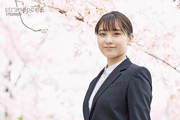 Japanische Frau in einem Anzug und Kirschblüten