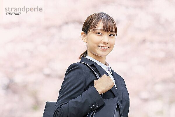Japanische Frau in einem Anzug und Kirschblüten