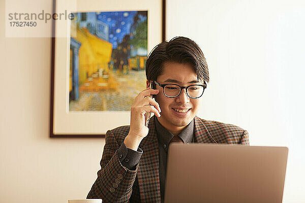 Japanischer Mann macht einen Telefonanruf