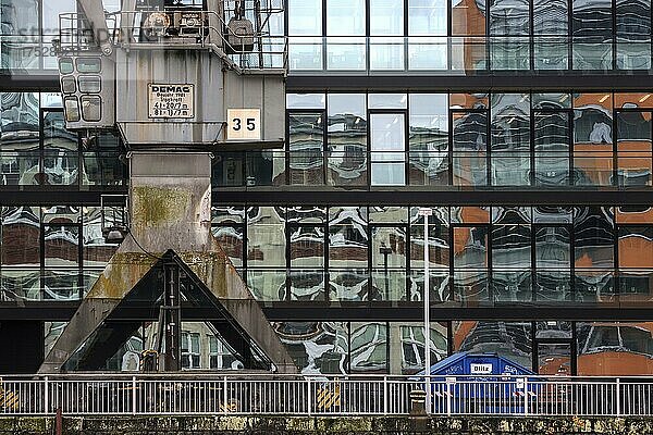 Alter Kran vor Bürogebäude mit Glasfassade  Medienhafen  Düsseldorf  Nordrhein-Westfalen  Deutschland  Europa