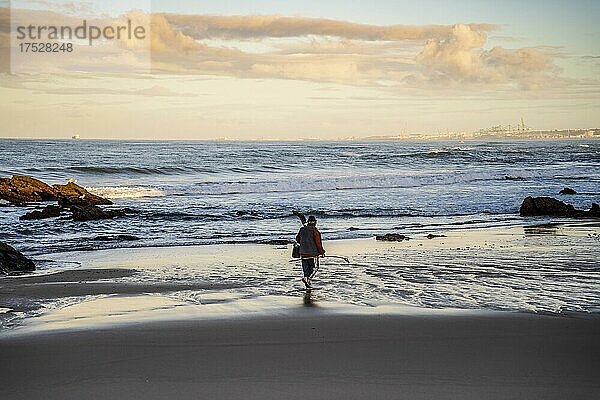 Ein Fischer bei einem Spaziergang am Strand von Samoqueira  zwischen Sines und Porto Covo  Alentejo  Portugal  Europa