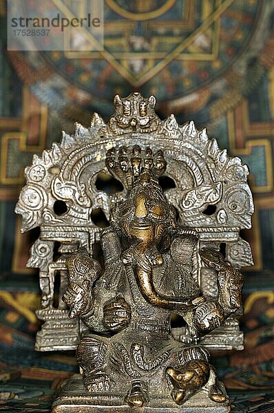 Bronzefigur des indischen Gottes Ganesha  Studiofotografie mit einem tibetanischen Thangka im Hintergrund