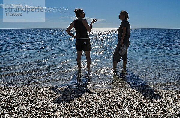 Zwei Frauen stehen im Wasser am Meer und diskutieren  Andalusien  Spanien  Europa