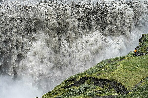 Mensch am Rande einer Schlucht  Canyon mit herabstürzenden Wassermassen  Dettifoss Wasserfall im Sommer  Nordisland  Island  Europa