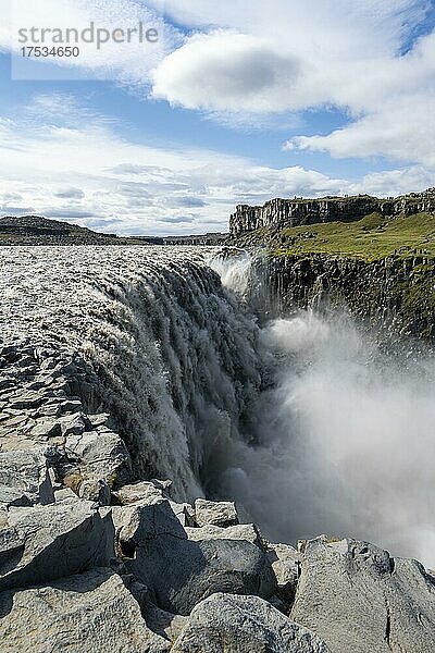 Frau steht vor Schlucht  Canyon mit herabstürzenden Wassermassen  Dettifoss Wasserfall im Sommer  Nordisland  Island  Europa