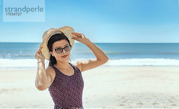 Frau in Hut glücklich am Strand  glücklich hübsche junge Frau im Urlaub  Urlaub Konzept