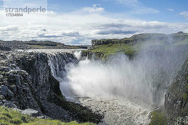 Frau steht vor Schlucht  Canyon mit herabstürzenden Wassermassen  Dettifoss Wasserfall im Sommer  Nordisland  Island  Europa