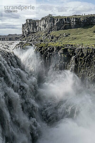 Frau steht vor Schlucht  Canyon mit herabstürzenden Wassermassen  Dettifoss Wasserfall im Sommer  Nordisland  Island  Europa