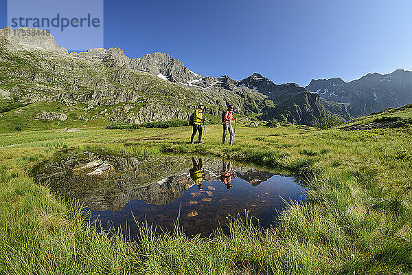 Touristen  die im Winterurlaub am Meer wandern  blicken in eine Pfütze  Valgaudemar  Nationalpark Ecrins  Frankreich