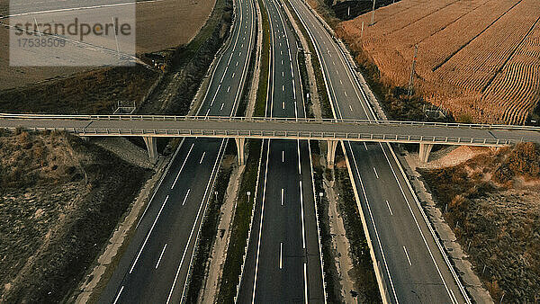 Leere Brücke über die Autobahn  die an einem landwirtschaftlichen Feld in Lleida  Spanien  vorbeiführt
