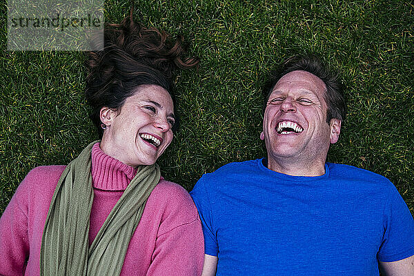 Cheerful couple lying on grass