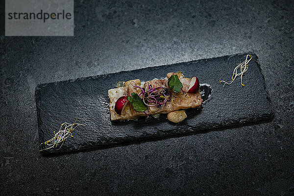 Studio shot of fine serving of trotter with radish