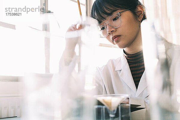 Junger Chemiker arbeitet konzentriert im Labor