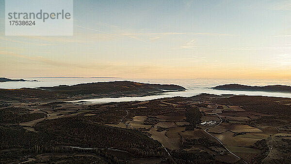 Spain  Province of Huesca  Estopinan del Castillo  Aerial panorama of mountains shrouded in sea of clouds at dusk