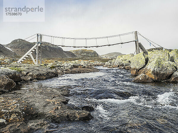 Suspension bridge over stream in Hardangervidda plateau