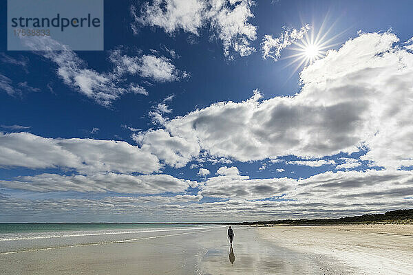 Australien  Südaustralien  Robe  Sommerwolken über der Silhouette einer Touristin  die allein am Fox Beach entlang spaziert