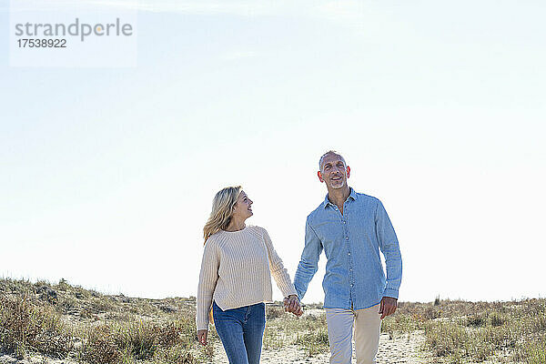 Couple walking together at dunes
