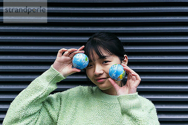 Woman with bangs holding small globes