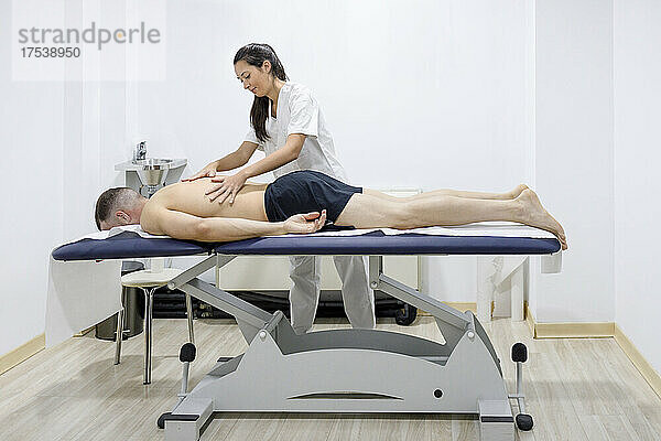 Physiotherapeut massiert Sportler im Rehabilitationszentrum