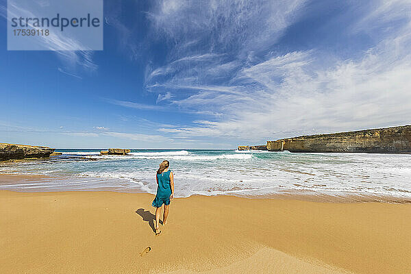 Female tourist walking alone along Sherbrook River Beach in Port Campbell National Park