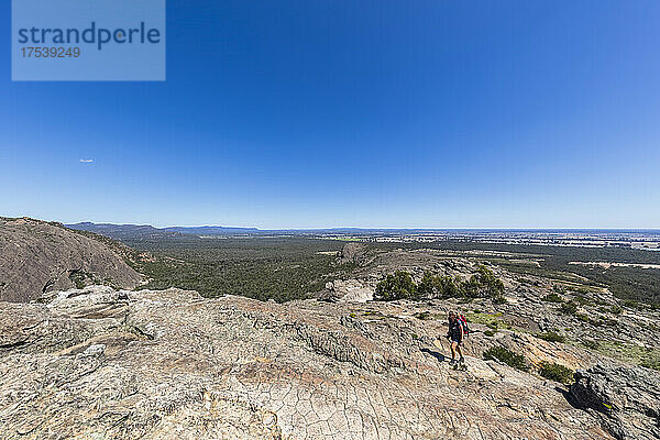 Australia  Victoria  Clear sky over female hiker ascending Hollow Mountain in Grampians National Park