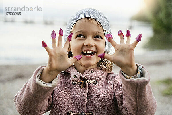 Playful girl with flower petals on fingers