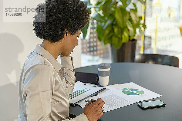 Geschäftsfrau Brainstorming über Dokument am Tisch im Büro