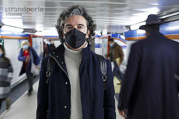 Mann mit schützender Gesichtsmaske steht an der U-Bahn-Station