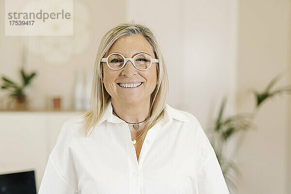 Happy businesswoman with eyeglasses in office