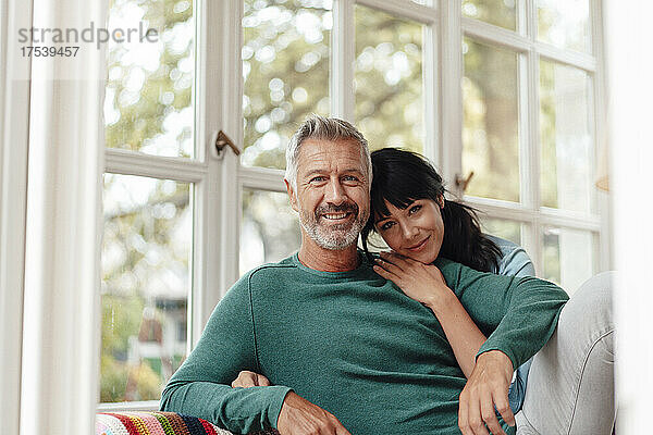 Woman leaning on man's shoulder at home