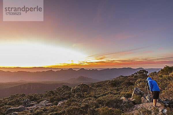 Australien  Victoria  männlicher Tourist  der bei Sonnenuntergang Fotos vom Mount William macht