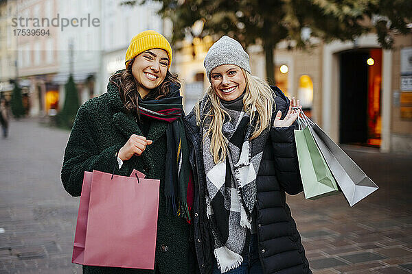 Cheerful women with shopping bags at market
