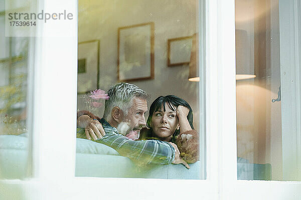 Heterosexual couple seen through window of house