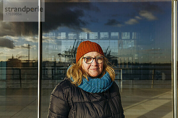Senior woman in front of glass wall